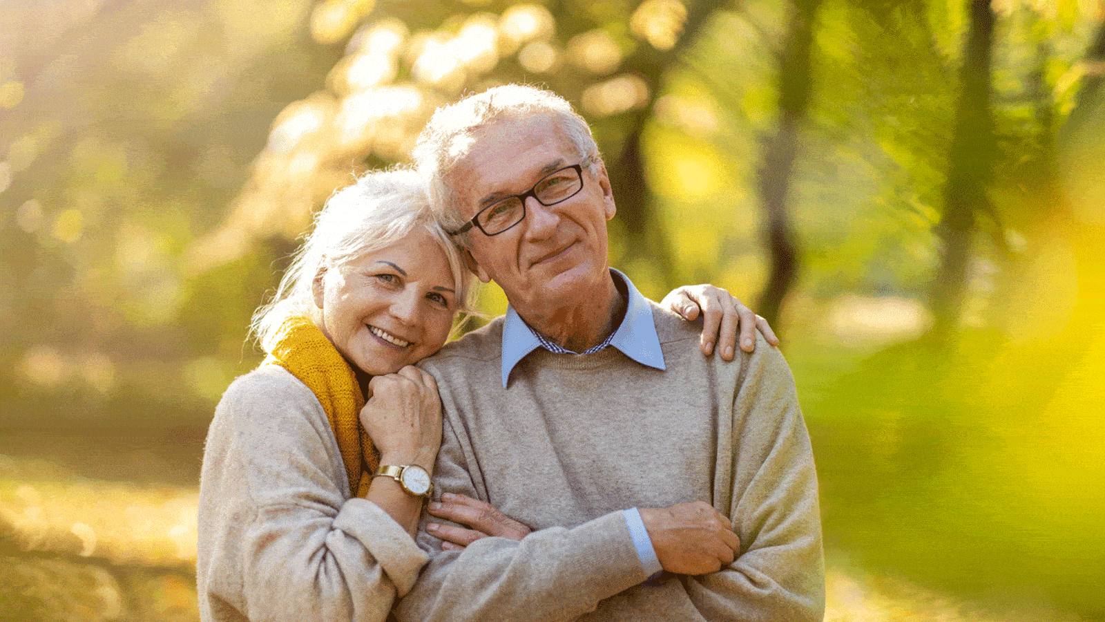 smiling elderly couple yellow light and trees life insurance