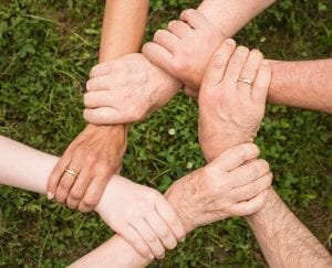 group holding hands green grass